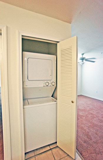 Stackable washer and dryer in laundry room with bifold door